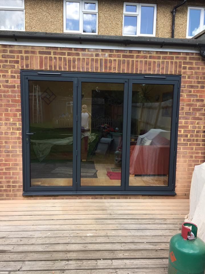 Anthracite aluminium bi-fold doors onto a deck